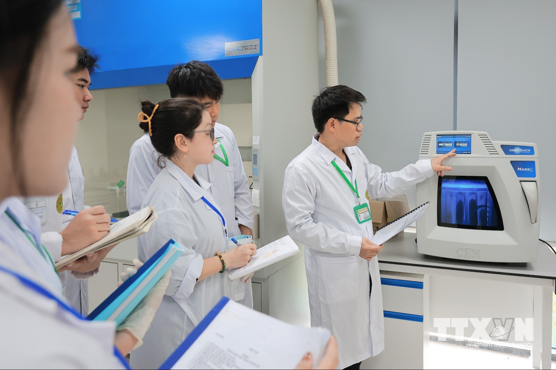 Giảng viên hướng dẫn sinh viên Khoa Tài nguyên và môi trường sử dụng máy phá mẫu vi sóng (Mars6) để phá hủy, phân hủy các mẫu hữu cơ và vô cơ (thực phẩm, đất, nước, dược phẩm) bằng axit đậm đặc dưới nhiệt độ và áp suất cao. (Ảnh: Lê Đông/TTXVN)